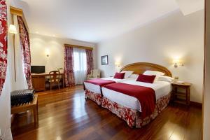 Habitación de hotel con cama grande y escritorio. en AZZ Peñafiel Las Claras Hotel & Spa, en Peñafiel