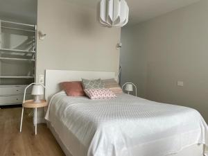 a white bedroom with a white bed with pillows at Casa de la plaza in Foz