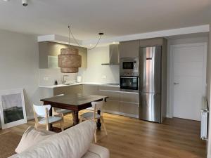 a kitchen and dining room with a table and a refrigerator at Casa de la plaza in Foz