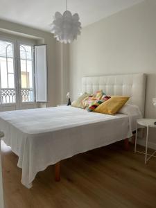 a white bedroom with a large bed in a room at Casa de la plaza in Foz