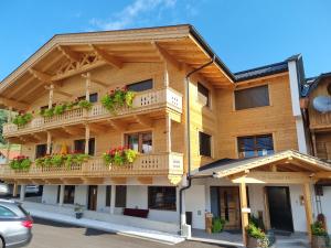 budynek z skrzyniami kwiatowymi na balkonach w obiekcie Greidlhof Alpstyle Apartments w mieście Fügen