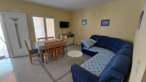 a living room with a blue couch and a table at Apartments Bolont in Pag