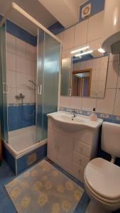 a bathroom with a toilet and a sink and a shower at Apartments Bolont in Pag +45 photos