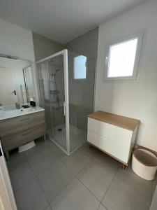 La salle de bains est pourvue d'une douche et d'un lavabo. dans l'établissement la villa d'Irissou YourHostHelper, à Andernos-les-Bains