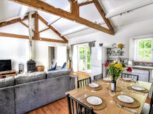 a kitchen and living room with a table and a couch at Damson Tree Cottage in Bridport