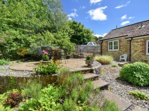 a garden with a stone path leading to a house at Damson Tree Cottage in Bridport