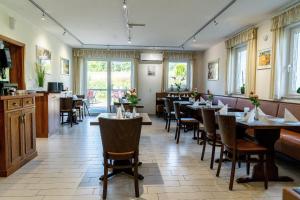 a restaurant with tables and chairs and windows at Land-gut-Hotel am Ring in Meuspath