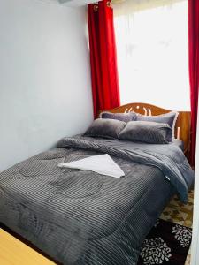 Bett in einem Zimmer mit rotem Fenster in der Unterkunft Loaded homes in Kikuyu