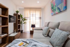 sala de estar con sofá y mesa en Viviendas con Fines Turísticos "Quivir Pidal" en Andújar