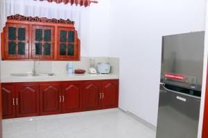 kuchnia z czerwonymi szafkami i lodówką ze stali nierdzewnej w obiekcie Bloomy Villa Bentota w mieście Bentota