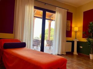 a bedroom with a bed and a window with a patio at Casa Rural Romana in Don Álvaro