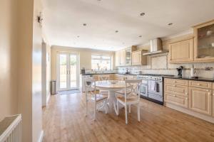 a kitchen with a table and chairs in it at SPACIOUS 3 BEDROOM HOME - GREAT FOR FAMILIES! in Slough
