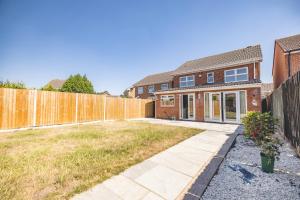 a brick house with a fence in a yard at SPACIOUS 3 BEDROOM HOME - GREAT FOR FAMILIES! in Slough