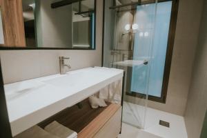 een badkamer met een witte wastafel en een glazen douche bij Catalina Plaza Hotel Sostenible in Las Palmas de Gran Canaria +37 foto's