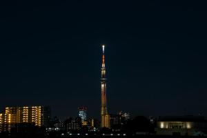 a tall building with a flag on it at night at Minn Machiya in Tokyo