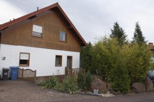 a large white house with a wooden roof at Ferienwohnung Weilerbach in Weilerbach