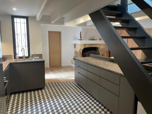 a large kitchen with a staircase in a room at Cap Ferret - Villa Sérénité - piscine, proche Océan et Bassin, classée 4 étoiles Meublé de tourisme in Lège-Cap-Ferret