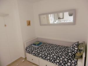 una piccola camera da letto con un letto e uno specchio di Appartement Ferrera Park vue mer a Cala Ferrera Altre 50 foto