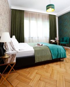 - une chambre avec un grand lit et des rideaux verts dans l'établissement Grand Phillip Cismigiu Park Downtown Bucharest, à Bucarest