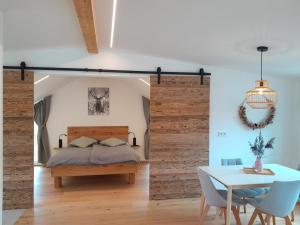a bedroom with a bed and a table with chairs at Ferienwohnung Bergblick Loft in Aschau im Chiemgau
