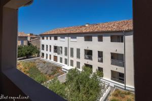 un edificio de apartamentos con vistas a un patio en Îlot COQUELICOT - PARKING GRATUIT SECURISE - AC CLiM - ASCENSEUR - BALCON, en LʼIsle-sur-la-Sorgue