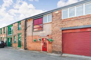 un edificio de ladrillo con dos puertas de garaje. en Dragon Loft Apartment en Harrogate