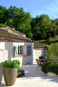 une maison avec une terrasse, une table et des chaises dans l'établissement Domaine Le Bois Des Dames, à Chantemerle-lès-Grignan