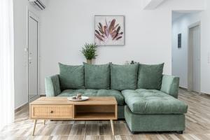 sala de estar con sofá verde y mesa de centro de madera en Myrte's View, en Asómatoi