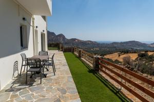 un patio con mesa y sillas en el lateral de una casa en Myrte's View, en Asómatoi