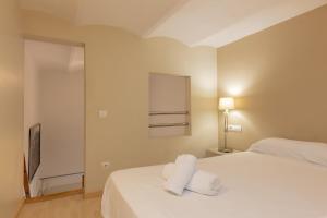 a bedroom with a bed with two towels on it at Lodging Apartments Sagrada Familia in Barcelona