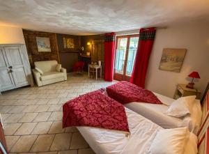 una camera da letto con un grande letto con tende rosse di La Fernande a Baratier