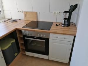 a kitchen with a stove top oven next to a counter at Ferienwohnung Civrilli 3 in Dippelsdorf