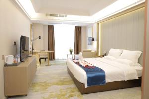 een hotelkamer met een groot bed en een televisie bij Five Elephants Hotel in Sihanoukville