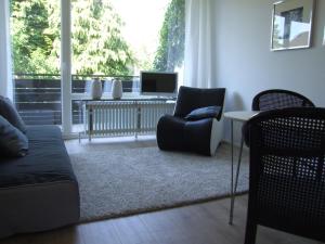 sala de estar con sofá, silla y TV en Das Stadthaus, en Bad Salzuflen