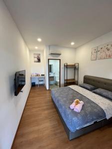 a bedroom with a bed with a toy on it at Raintown Cottage in Taiping