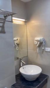 W łazience znajduje się biała umywalka i lustro. w obiekcie Khách sạn Thiên Đường - Paradise Hotel w mieście Yên Lô