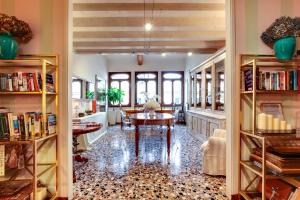 a living room with a table and bookshelves at La Villeggiatura in Venice