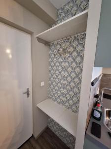 a small kitchen with white shelves and a wall at Studio Trenz - stylish duo studio in Groningen