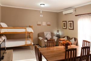 a living room with a bunk bed and a table at The Falls Guest House in Augrabies