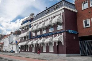a red brick building with a hotel on a street at Studio Trenz - stylish duo studio in Groningen