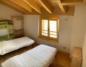 Berbenno di ValtellinaにあるChalet Baita delle Favole di RosaRitaのベッドルーム1室(ベッド2台、窓付)