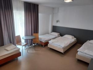 a hotel room with two beds and a table at WOSiR Drzonków in Zielona Góra