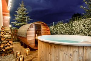 una bañera de hidromasaje en una terraza de madera con un árbol en TATRYSTAY Cactus Luxury Villa High Tatras private Wellness, en Veľká Lomnica