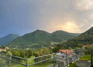 a view of a mountain range with a rainbow in the sky at EderaRooms in Cerano d'Intelvi