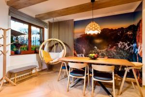 a dining room with a large painting on the wall at TATRYSTAY Cactus Luxury Villa High Tatras private Wellness in Veľká Lomnica