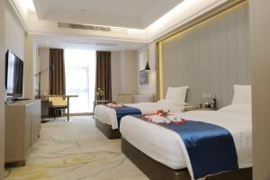 ein Hotelzimmer mit 2 Betten und einem TV in der Unterkunft Five Elephants Hotel in Sihanoukville