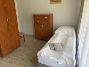 a small bedroom with a bed and a dresser at Villa Bartosz in Międzywodzie
