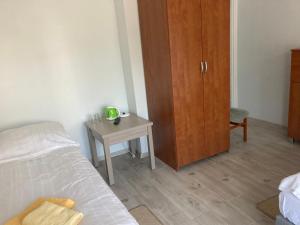 a bedroom with a bed and a cabinet and a table at Villa Bartosz in Międzywodzie