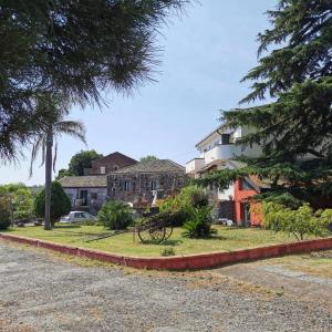 una casa en medio de una calle con árboles en Villa Alessio - Case Vacanza con Piscina sull'Etna, en Puntalazzo