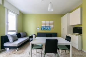 sala de estar con mesa, sillas y sofá en Condominio Commerciale, en Lido di Jesolo